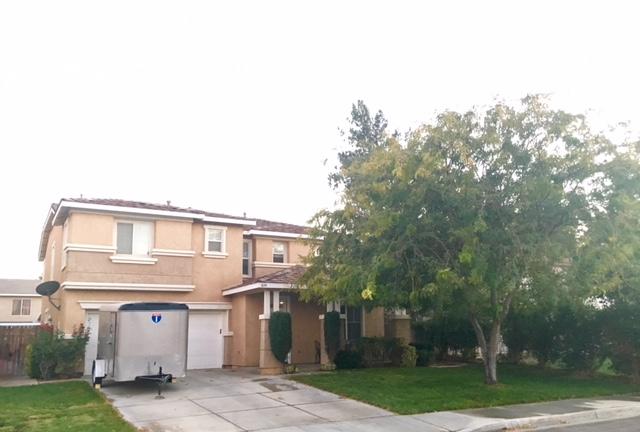 a front view of a house with a garden and trees