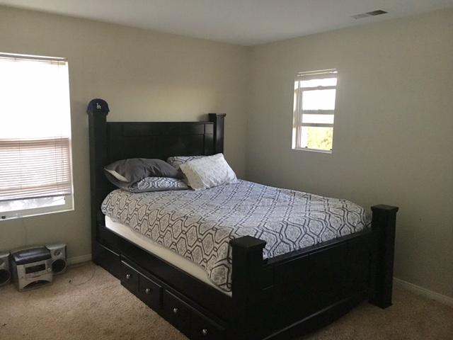 1844 Minter Way Lancaster, CA 93534 - Photo 13 of 15 a bed sitting in a bedroom next to a window