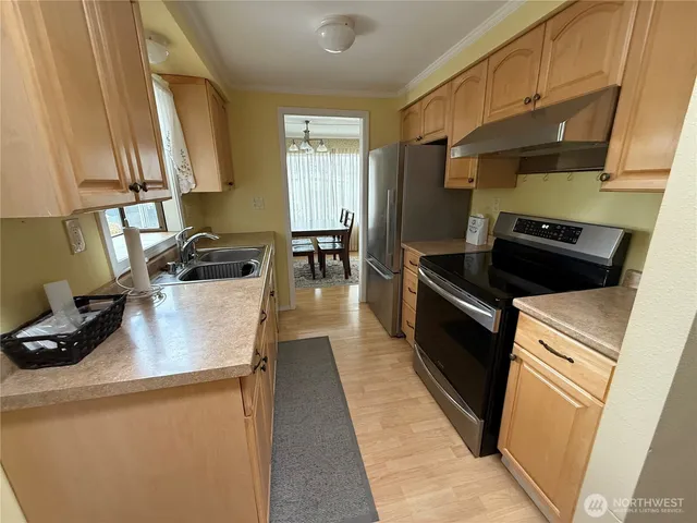 a kitchen with a sink a stove and cabinets