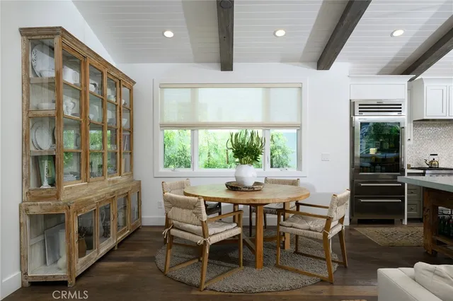 a dining room with furniture large windows and a chandelier