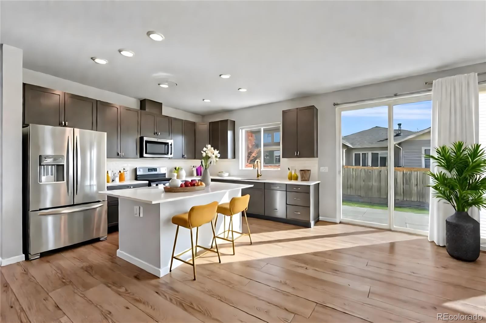 15902 Stringhalt Way Parker, CO 80134 - Photo 12 of 48 a kitchen with granite countertop a refrigerator and a stove top oven