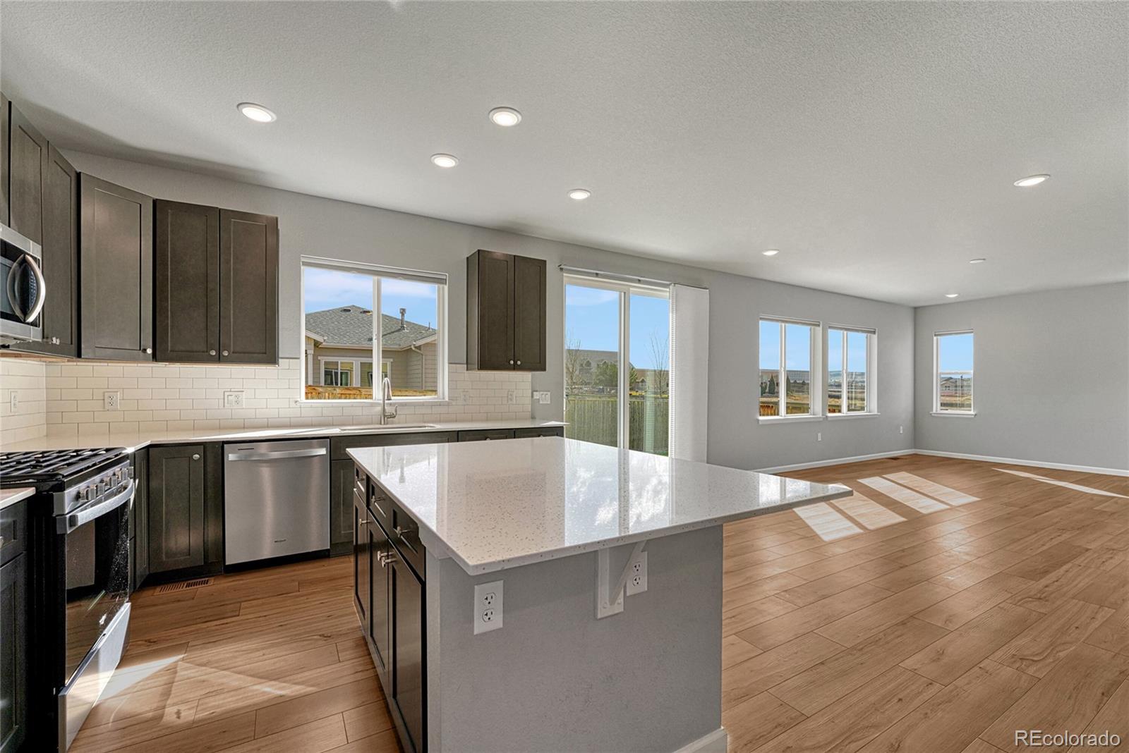 15902 Stringhalt Way Parker, CO 80134 - Photo 13 of 48 a kitchen with stainless steel appliances granite countertop a sink stove and oven