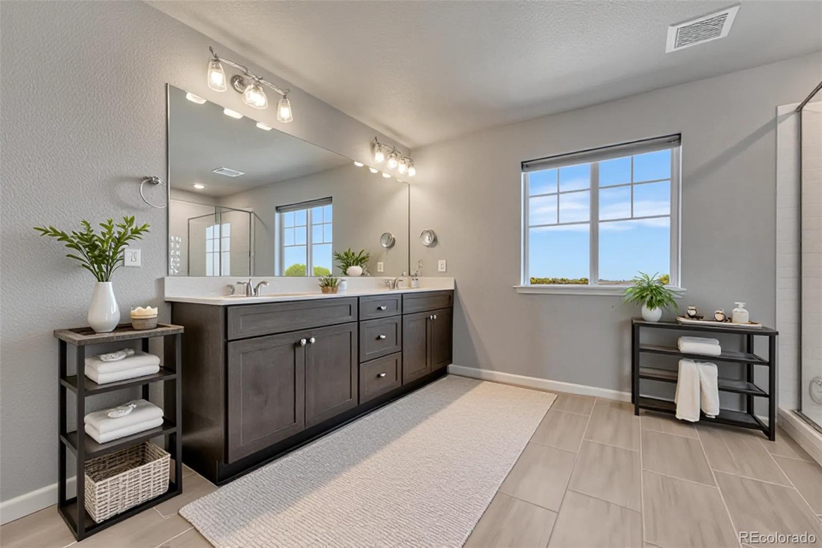 15902 Stringhalt Way Parker, CO 80134 - Photo 34 of 48 a spacious bathroom with a double vanity sink and a mirror