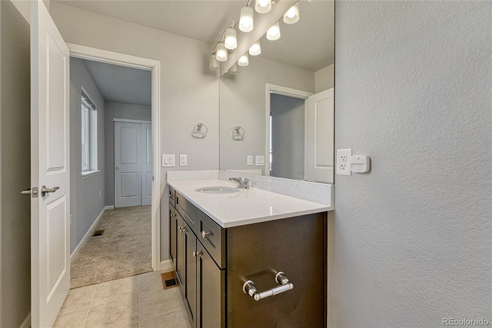 15902 Stringhalt Way Parker, CO 80134 - Photo 40 of 48 a bathroom with a sink vanity and mirror