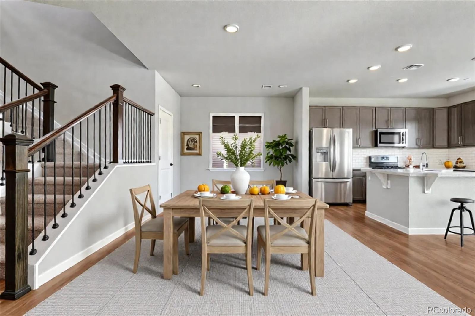 15902 Stringhalt Way Parker, CO 80134 - Photo 4 of 48 a dining room with stainless steel appliances kitchen island granite countertop a dining table chairs and a refrigerator
