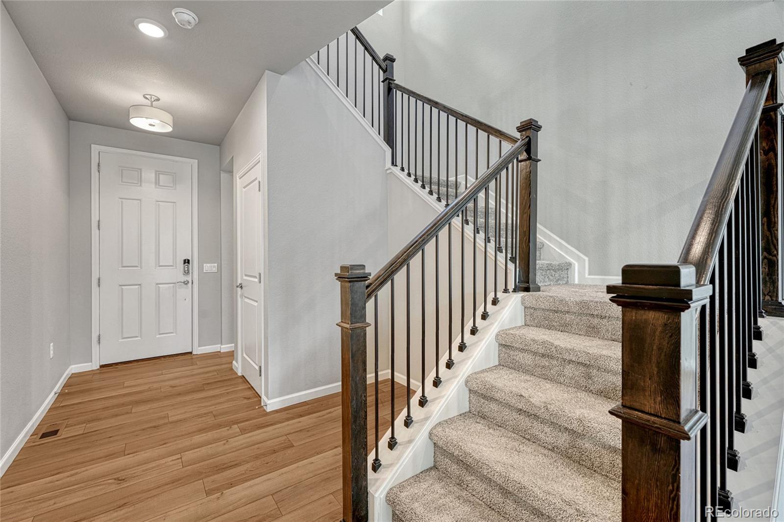 15902 Stringhalt Way Parker, CO 80134 - Photo 5 of 48 a view of a hallway with wooden floor and entryway