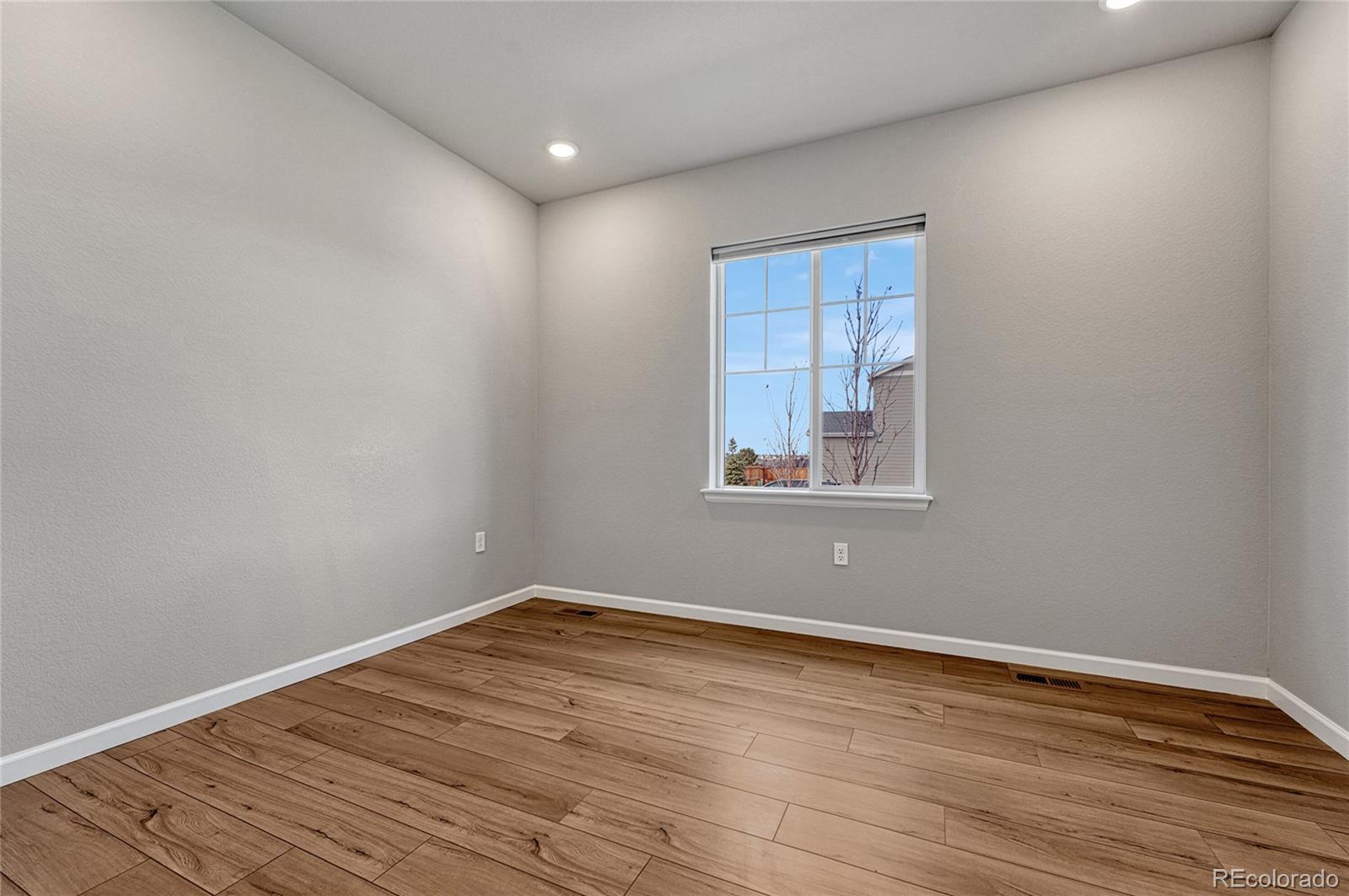 15902 Stringhalt Way Parker, CO 80134 - Photo 7 of 48 a view of empty room with wooden floor and fan