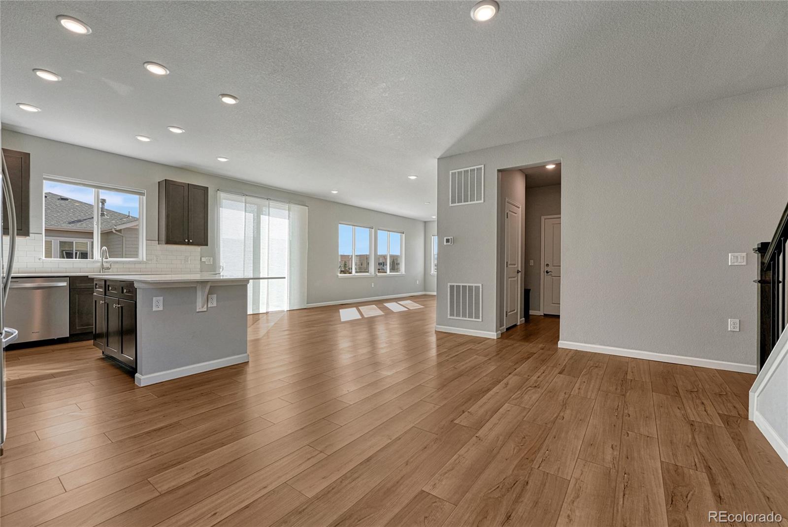 15902 Stringhalt Way Parker, CO 80134 - Photo 10 of 48 a view of a kitchen with a fridge and wooden floor