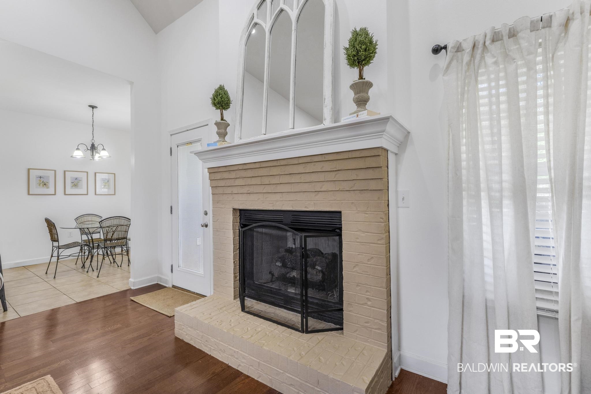 35814 Delvan Lane Bay Minette, AL 36507 - Photo 12 of 53 Vaulted ceiling living space with a brick-surround fireplace, wood-finish flooring, and white window blinds