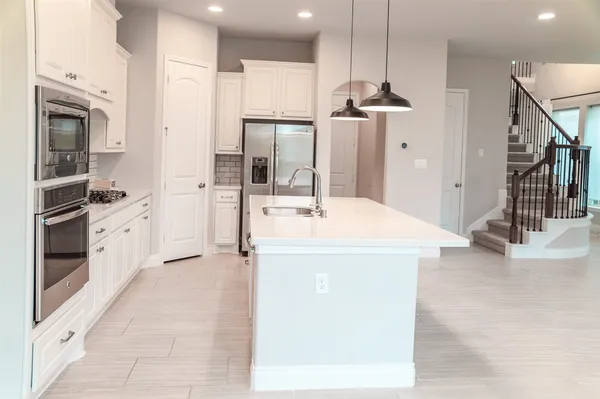 a kitchen with a sink stainless steel appliances and cabinets