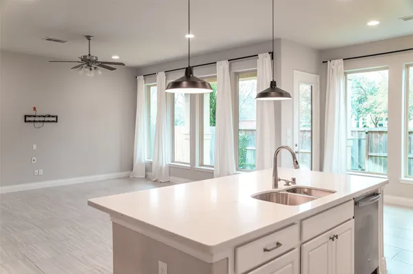 a kitchen with a sink a large window and wooden floor