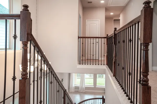 a view of staircase with lots of frames on wall and wooden floor