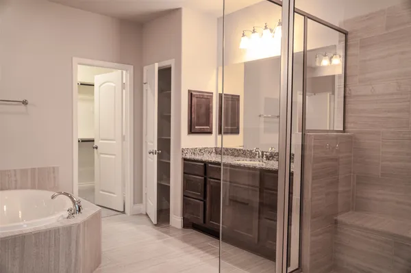 a bathroom with a tub sink shower and mirror
