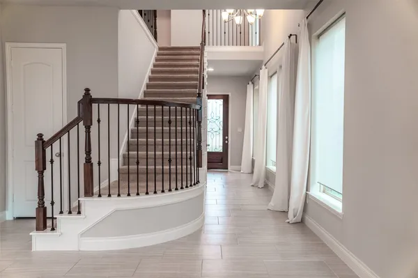 a view of staircase with railing and white walls