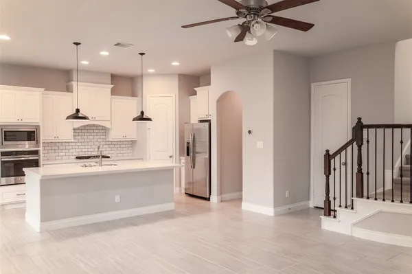 a large white kitchen with a stove a sink and a refrigerator