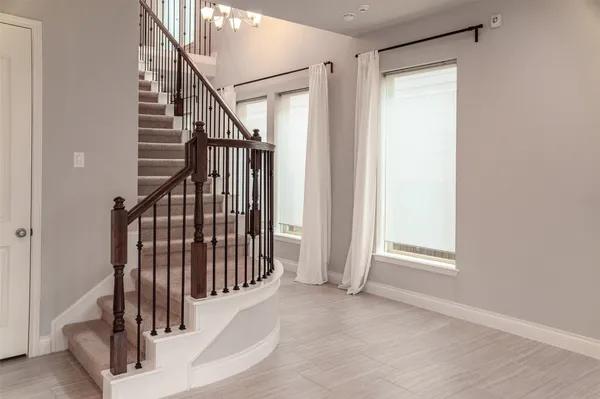 a view of staircase with railing and white walls
