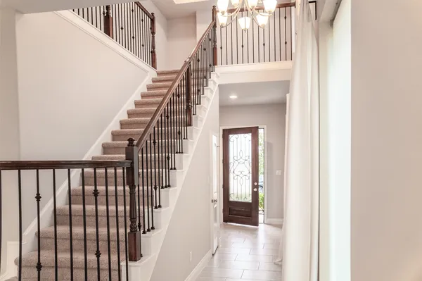 a view of staircase with railing and white walls
