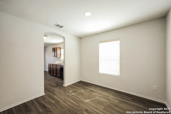 an empty room with wooden floor and a window