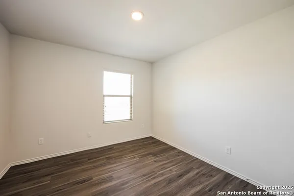 an empty room with wooden floor and window