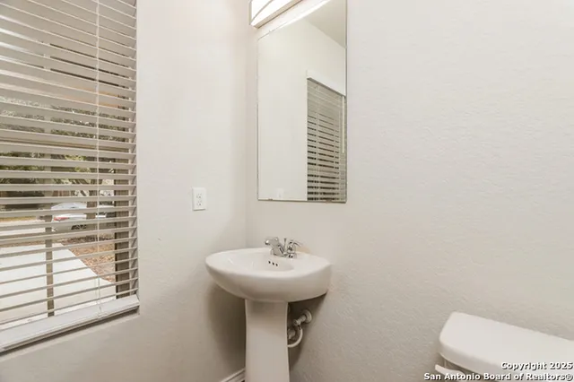 a bathroom with a sink a toilet and mirror