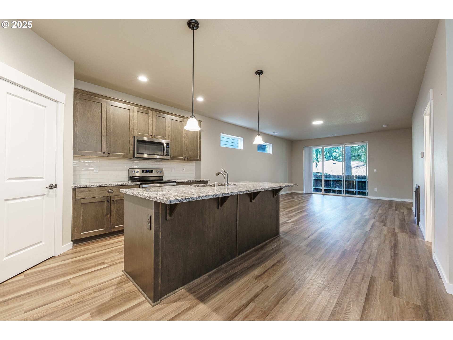7135 South 13th Street Ridgefield, WA 98642 - Photo 3 of 40 a kitchen with kitchen island white cabinets and stainless steel appliances