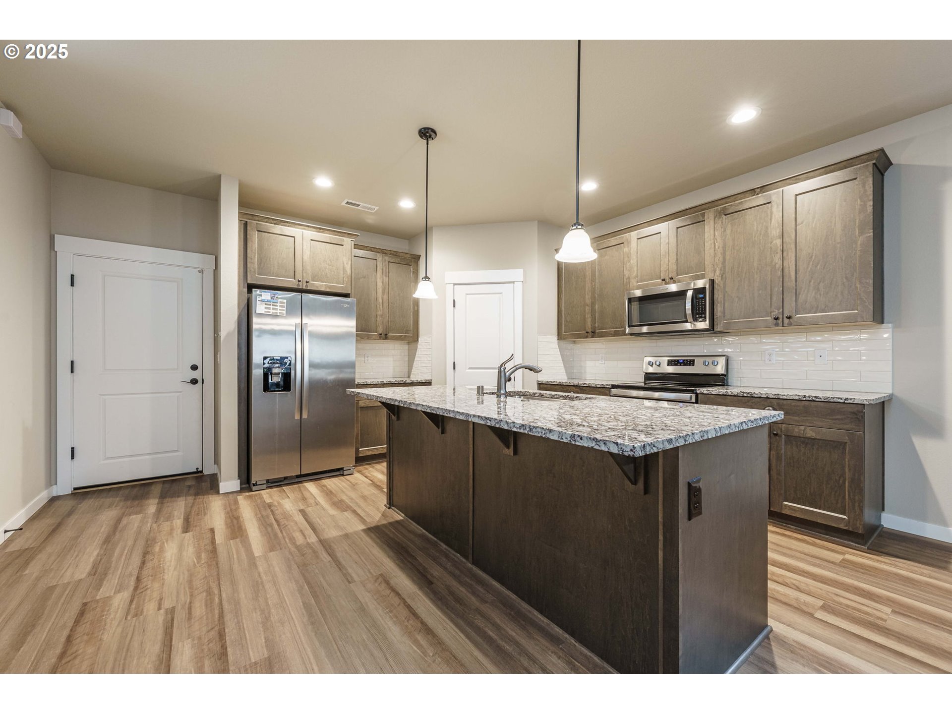 7135 South 13th Street Ridgefield, WA 98642 - Photo 4 of 40 a kitchen with kitchen island a sink stainless steel appliances and cabinets