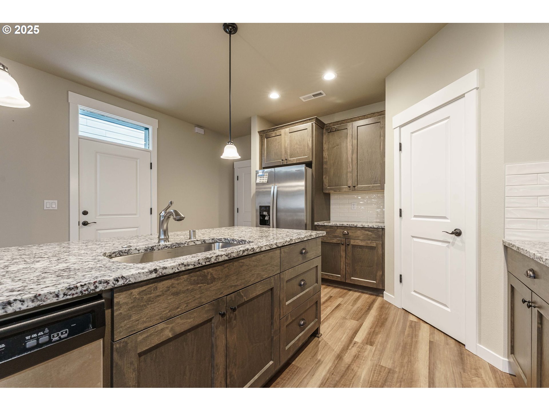 7135 South 13th Street Ridgefield, WA 98642 - Photo 5 of 40 a kitchen with a sink dishwasher a stove and a refrigerator with wooden floor