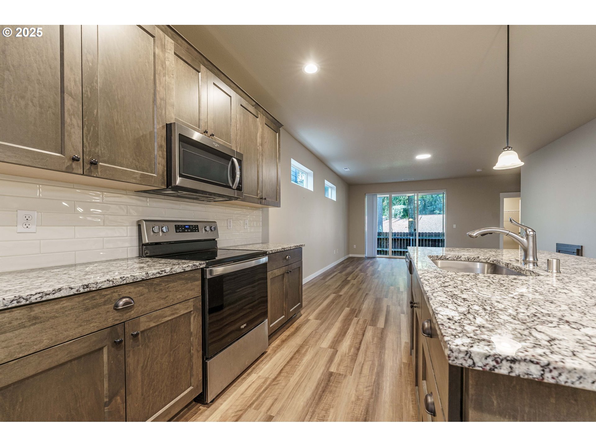7135 South 13th Street Ridgefield, WA 98642 - Photo 6 of 40 a kitchen with stainless steel appliances granite countertop a sink a stove top oven a granite counter space and cabinets