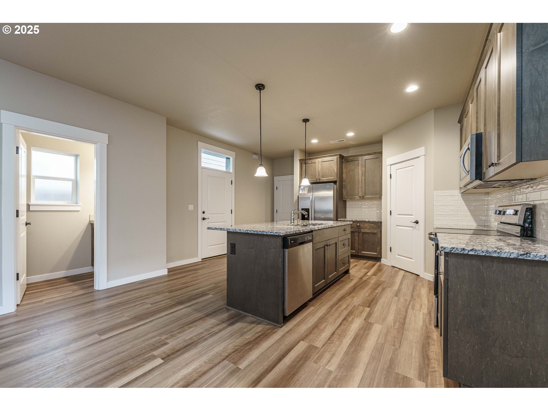 7135 South 13th Street Ridgefield, WA 98642 - Photo 8 of 40 a large kitchen with kitchen island a sink stainless steel appliances and cabinets