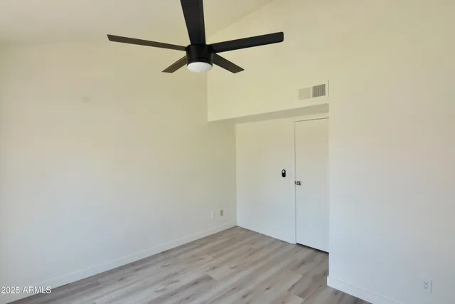 a view of a small space with wooden floor and a ceiling fan