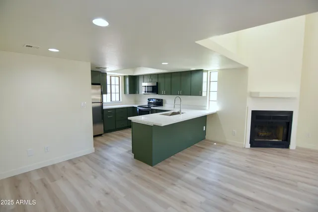 a kitchen with a sink cabinets and wooden floor