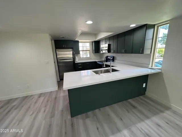 a kitchen with a sink cabinets and wooden floor