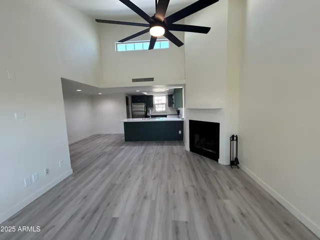a view of a room with wooden floor and a ceiling fan
