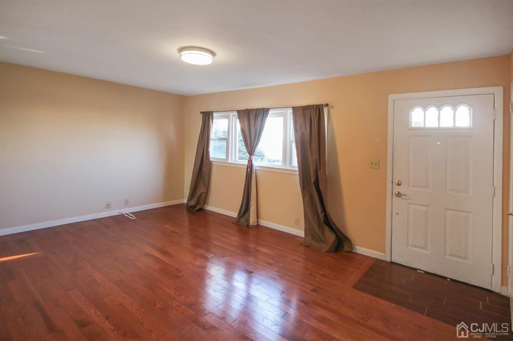 49 Racetrack Road East Brunswick, NJ 08816 - Photo 3 of 20 an empty room with wooden floor and windows