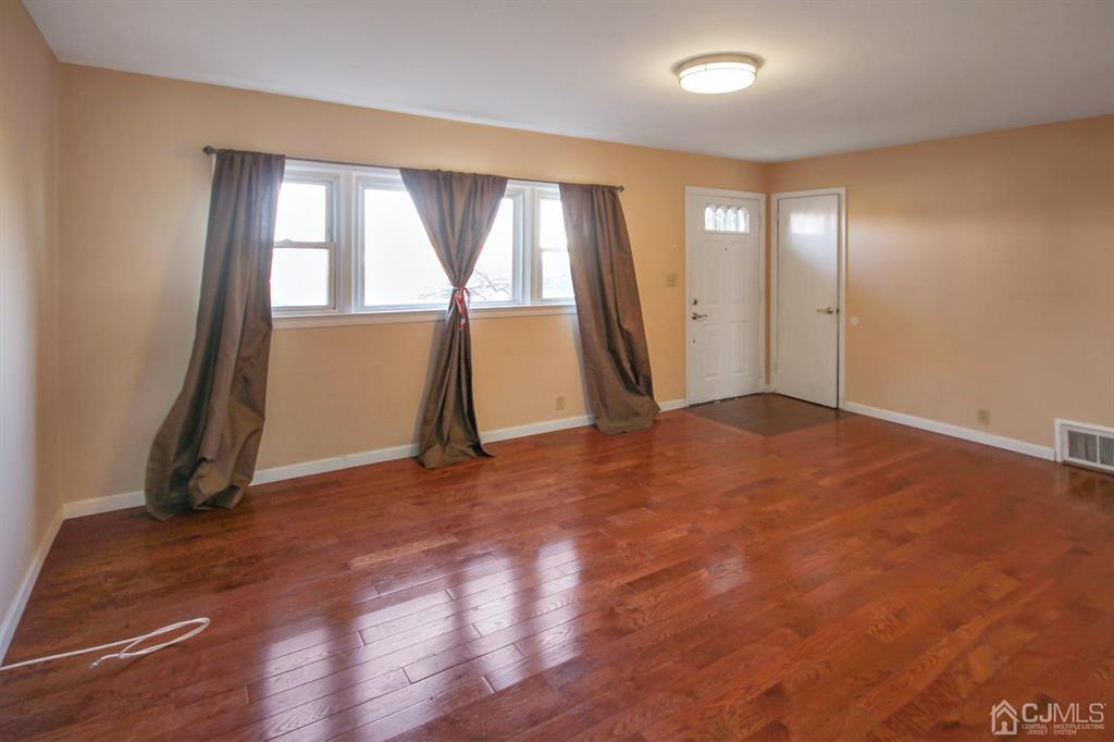 49 Racetrack Road East Brunswick, NJ 08816 - Photo 4 of 20 an empty room with wooden floor and windows