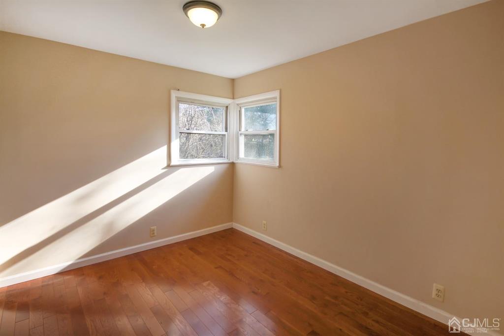 49 Racetrack Road East Brunswick, NJ 08816 - Photo 8 of 20 a view of an empty room with wooden floor and a window