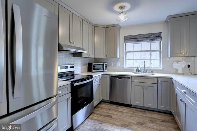 a kitchen with stainless steel appliances granite countertop a stove sink and cabinets