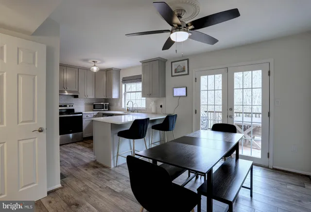 a kitchen with a dining table chairs and refrigerator