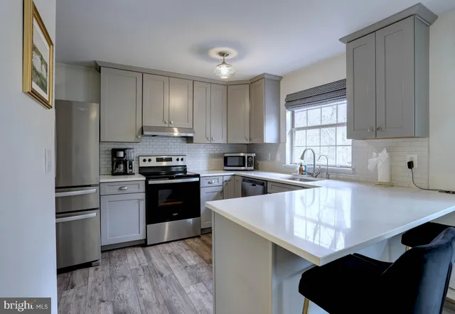 a kitchen with granite countertop a stove a sink and a refrigerator