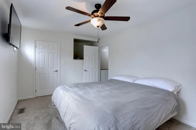 a bedroom with a bed and a flat tv screen on the dresser