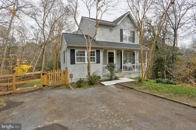 a view of a house with a yard and large tree