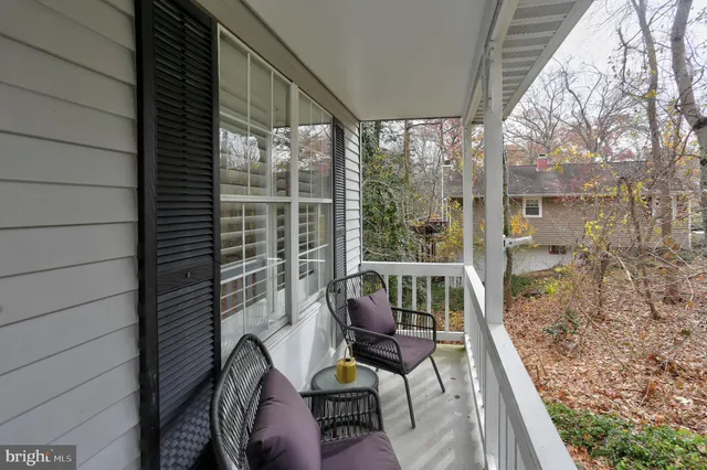 a balcony view with a large window and sitting space