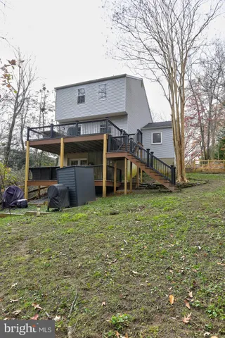 a view of a house with a big yard and large tree