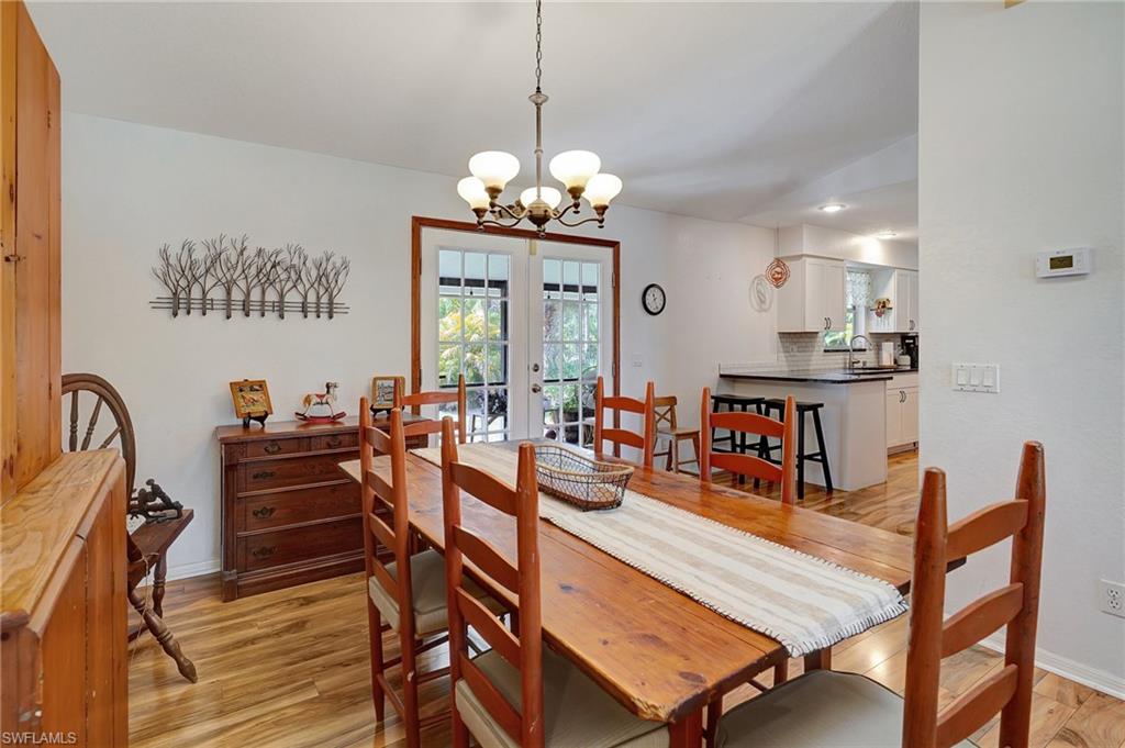 3520 2nd Avenue Northeast Naples, FL 34120 - Photo 16 of 39 a view of a dining room with furniture a chandelier and wooden floor