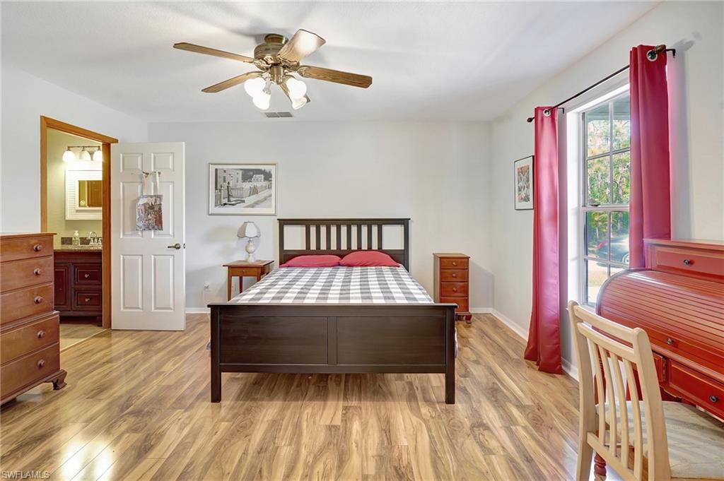 3520 2nd Avenue Northeast Naples, FL 34120 - Photo 26 of 39 a bedroom with a bed and a dresser with wooden floor