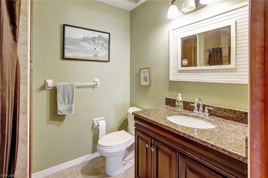 3520 2nd Avenue Northeast Naples, FL 34120 - Photo 29 of 39 a bathroom with a granite countertop toilet sink and mirror