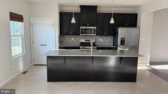 a kitchen with stainless steel appliances a refrigerator a sink a stove and microwave