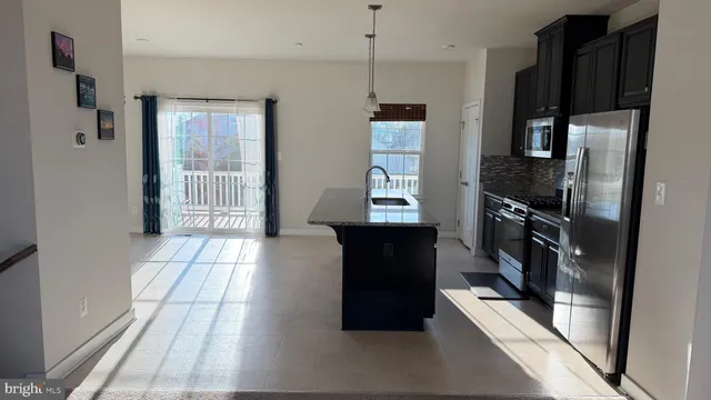 a view of a kitchen with refrigerator and windows