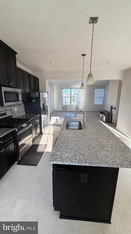 a kitchen with stainless steel appliances granite countertop a sink stove and microwave