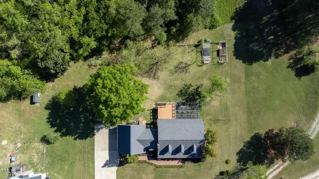 an aerial view of green landscape with trees houses and mountain view